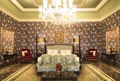 a bedroom with a bed and a chandelier at Rajmahal Palace RAAS in Jaipur