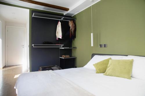 a bedroom with a white bed and green walls at Ca Bussun in Domodossola