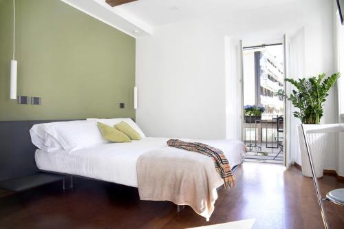 1 dormitorio con 1 cama con sábanas blancas y paredes verdes en Ca Bussun, en Domodossola