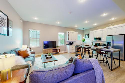 a living room with a purple couch and a kitchen at Bentonvilla in Bentonville