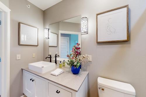 een badkamer met een wastafel, een toilet en een spiegel bij Bentonvilla in Bentonville