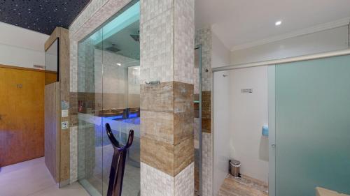 a shower in a bathroom with a glass door at Motel DUBAI BH in Belo Horizonte