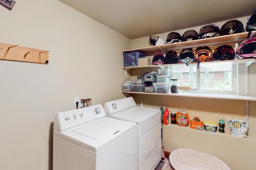 a laundry room with a washing machine and shelves at Pine-Loch Sun Retreat in Ronald