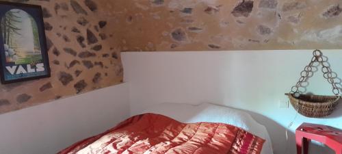 a bedroom with a bed and a hanging basket at gite Sous le Figuier in Vals-les-Bains