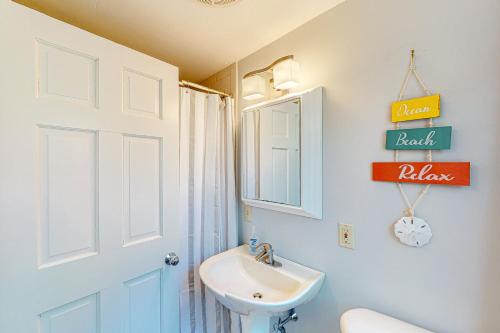 a white bathroom with a sink and a mirror at Hazel Retreat in Barnstable