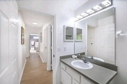 a bathroom with a sink and a large mirror at Fabulous, Quiet Family Resort Vacation Home, South Facing Pool, at Lake Berkley Resort, Near Disney, SeaWorld in Kissimmee