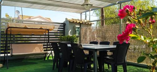 a patio with a table and chairs and a fence at Spiridoula Luxury Villa in Roda