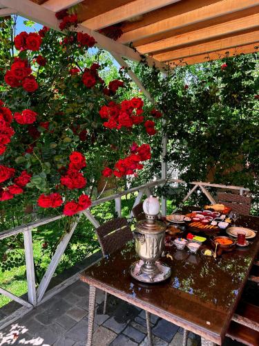 a table with red roses on a patio at Qafqaz Fountain Villa in Gabala