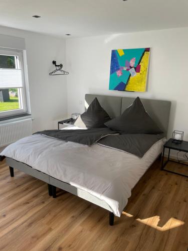 1 dormitorio con 1 cama con una pintura en la pared en Ferienwohnung Ahr / Ahrtal, en Altenahr