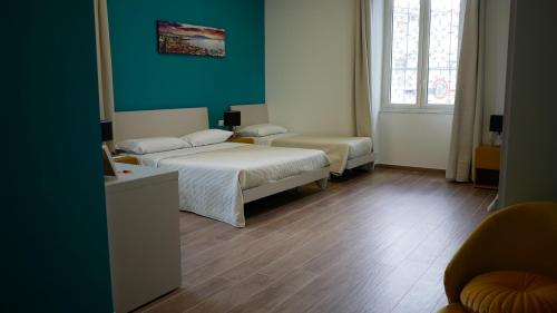 a bedroom with two beds and a green wall at Terminal 1 Guest House in Naples