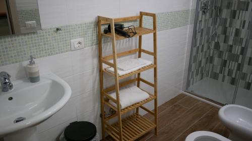 Łazienka z drewnianym wieszakiem na ręczniki obok umywalki w obiekcie Terminal 1 Guest House w mieście Napoli