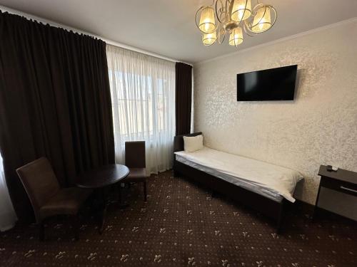 Habitación de hotel con cama y TV de pantalla plana. en Hotel Merry Club en Malyye Khutora
