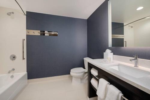 a bathroom with a sink and a toilet and a tub at Residence Inn by Marriott Indianapolis Keystone in Indianapolis