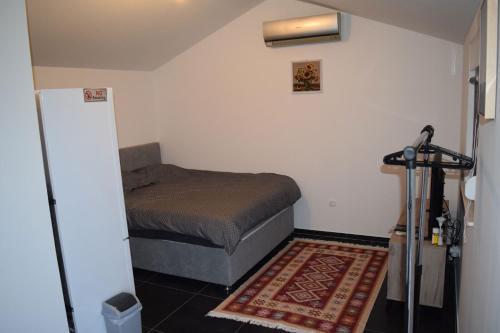 a small bedroom with a bed and a rug at Apartman Maga in Čapljina