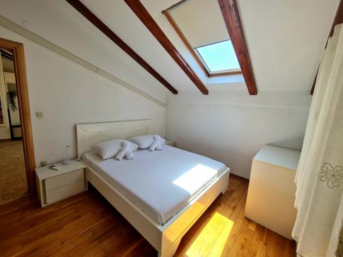 um quarto com uma cama com duas almofadas e uma janela em Apartments Roko em Zadar