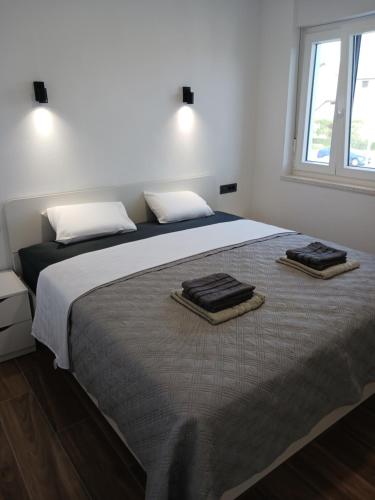 een slaapkamer met een groot bed met twee handdoeken erop bij Apartman Villa Marina in Vodice