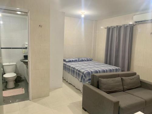 sypialnia z łóżkiem, krzesłem i toaletą w obiekcie Lindo Flat em Ponta Negra - Natal w mieście Natal