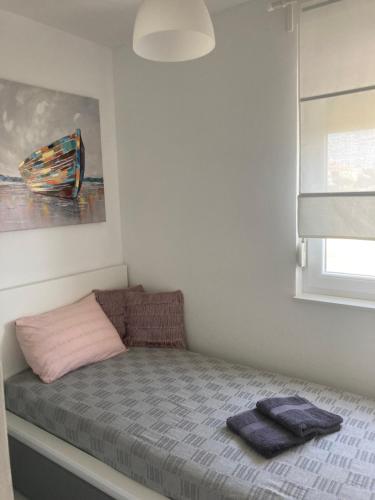 a small bed in a room with a painting at Apartman Hmelina in Vrsi