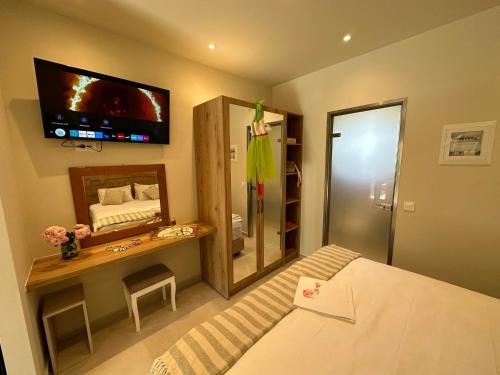 1 dormitorio con 1 cama y TV en la pared en Sea Side Studios, en Tsilivi