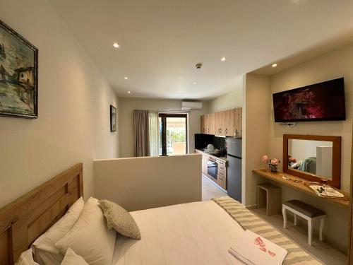 a bedroom with a large bed and a kitchen at Sea Side Apartments & Studios-Renovated in Tsilivi