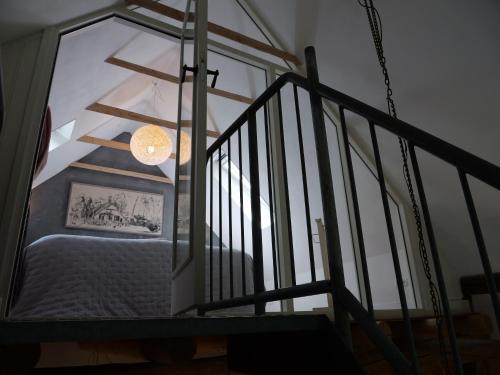 a room with a staircase with a bed and a window at Landgoedhoeve Vosbergen in Heerde