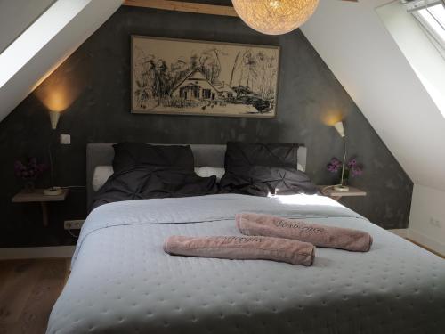 HeerdeにあるLandgoedhoeve Vosbergenのベッドルーム1室(大型ベッド1台、タオル2枚付)