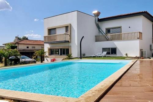 a villa with a swimming pool in front of a house at Casas Castelhano - Minho Braga in Mire de Tibães