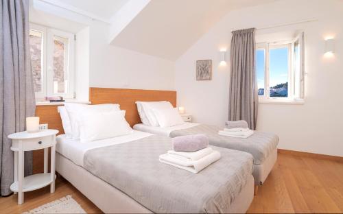 2 Betten in einem Zimmer mit 2 Fenstern in der Unterkunft Villa Moscatello in Hvar