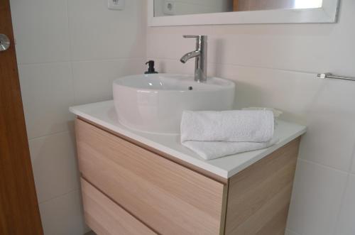 ein Badezimmer mit einem weißen Waschbecken und einer Theke in der Unterkunft Horta la Vita in Horta
