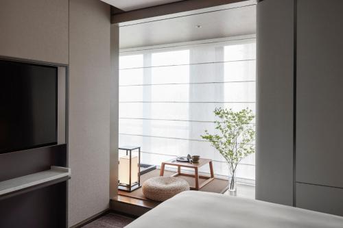 a bedroom with a window with a bed and a table at JW Marriott Hotel Shenzhen in Shenzhen