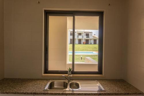 um lavatório num quarto com uma janela em RochAlvor em Alvor