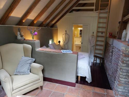 a bedroom with a bed and a chair in a room at Landgoedhoeve Vosbergen in Heerde