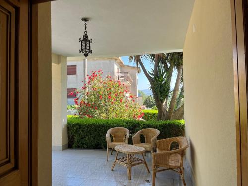a patio with a table and chairs and flowers at Villa Claudia - casa vacanze in Agropoli