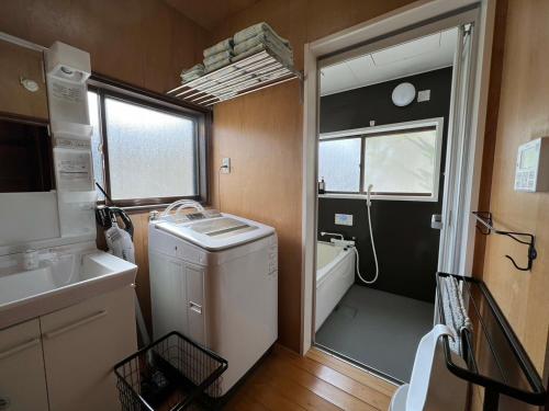 a small bathroom with a sink and a washing machine at SUMITSUGU HOUSE Grandpa in Kumamoto