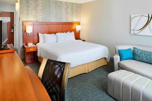 a hotel room with a bed and a couch at Courtyard by Marriott Tucson Williams Centre in Tucson