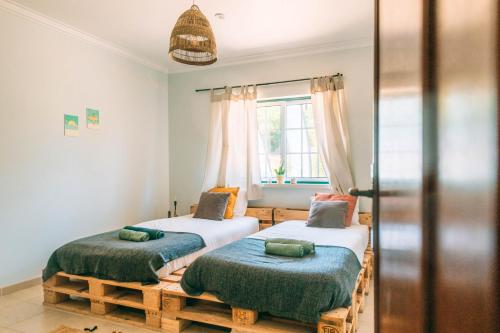 una camera con 2 letti singoli e una finestra di The Kitesurf Lodge a Casal do Narcizo