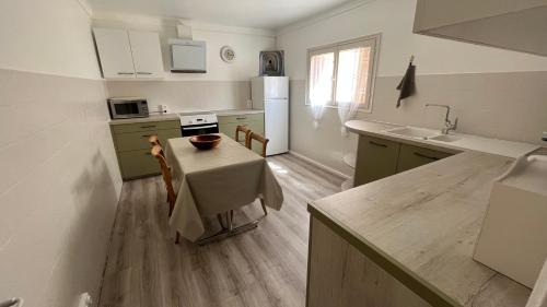 une cuisine avec une table et des placards verts dans l'établissement LA CASA GIL, à Ajaccio