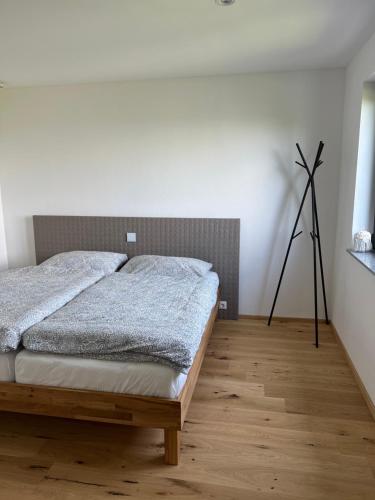 グムンデンにあるGrünberg Apartmentsのウッドフロアのベッドルーム1室(ベッド1台付)