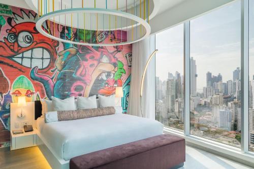 a bedroom with a mural and a bed in front of a window at W Panama in Panama City