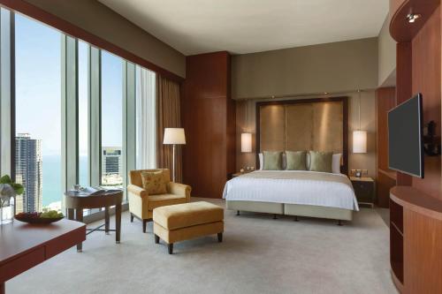a large hotel room with a bed and a chair at JW Marriott Marquis City Center Doha in Doha