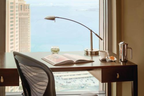 a desk with a book and a lamp and a book sidx sidx sidx at JW Marriott Marquis City Center Doha in Doha