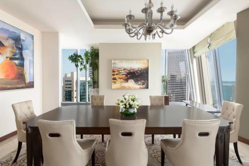 a dining room with a black table and white chairs at JW Marriott Marquis City Center Doha in Doha
