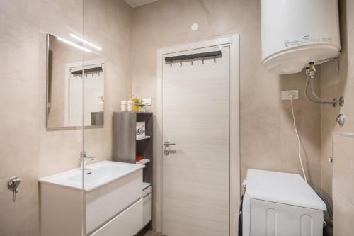 a bathroom with a sink and a toilet and a mirror at Villa Skrila in Fažana