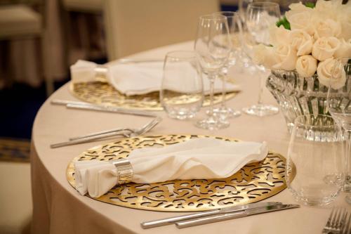a table with plates and napkins and wine glasses at JW Marriott Marquis City Center Doha in Doha
