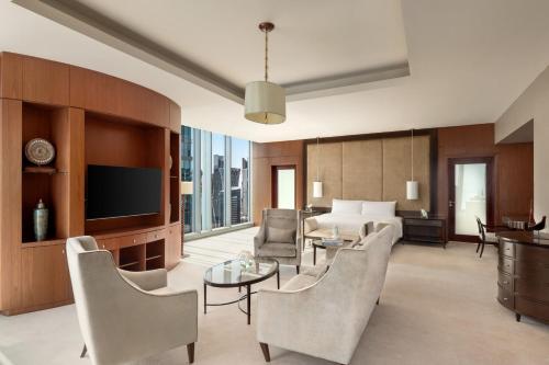 a living room with a bed and a room with a tv at JW Marriott Marquis City Center Doha in Doha