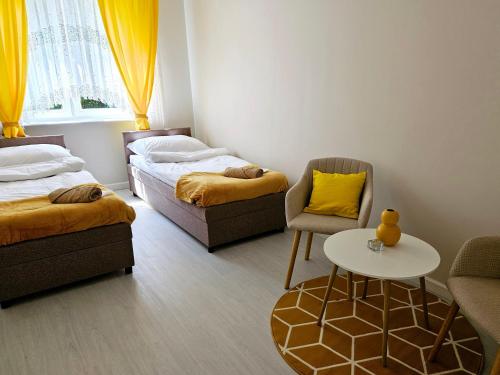 a room with two beds and a table and a chair at Sweet Dream in Gdańsk
