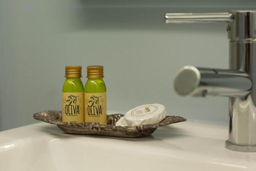 two bottles of mustard sitting on a bathroom sink at Levante by PortofinoHomes in Portofino