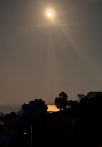 a full moon rising over the ocean at night at Villa Gratia Alba in Amphoe Koh Samui