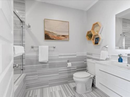 a white bathroom with a toilet and a sink at CozySuites Dream 1BR, PPG Paints Arena, Pitts in Pittsburgh