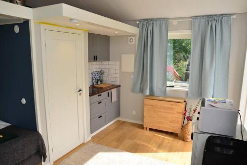 una pequeña cocina con cama y ventana en Cottage for visiting sea, city, forest en Holm